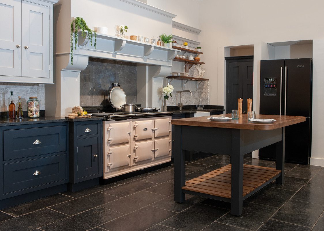 A Blush AGA cooker in a navy blue kitchen.